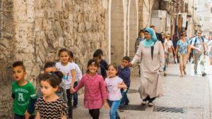 10 May 2018 A group of young children and their female Muslam guardian in traditional modest dress walking in the old city of Jerusalem Israel