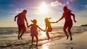 happy family jumping together on the beach